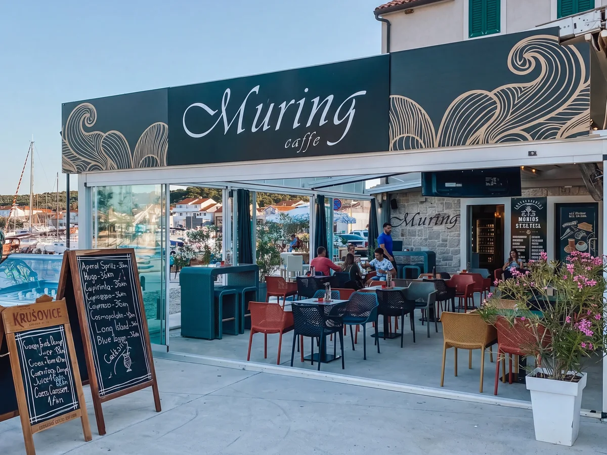 Caffe Bar Muring – pročelje kafića s natpisom i terasom uz marinu Betine na otoku Murteru