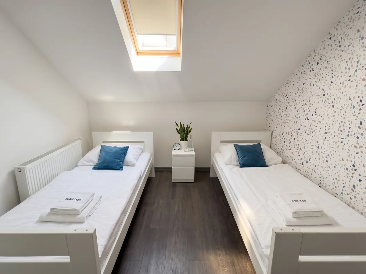 Kaptol Rooms – twin soba s dva jednokrevetna kreveta, plavim jastucima i terrazzo akcentnim zidom