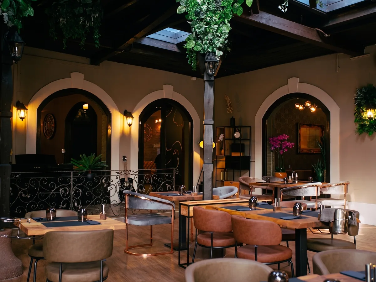 Kaptolska Klet Zagreb – elegant winter garden with arched windows, hanging plants and ambient lighting