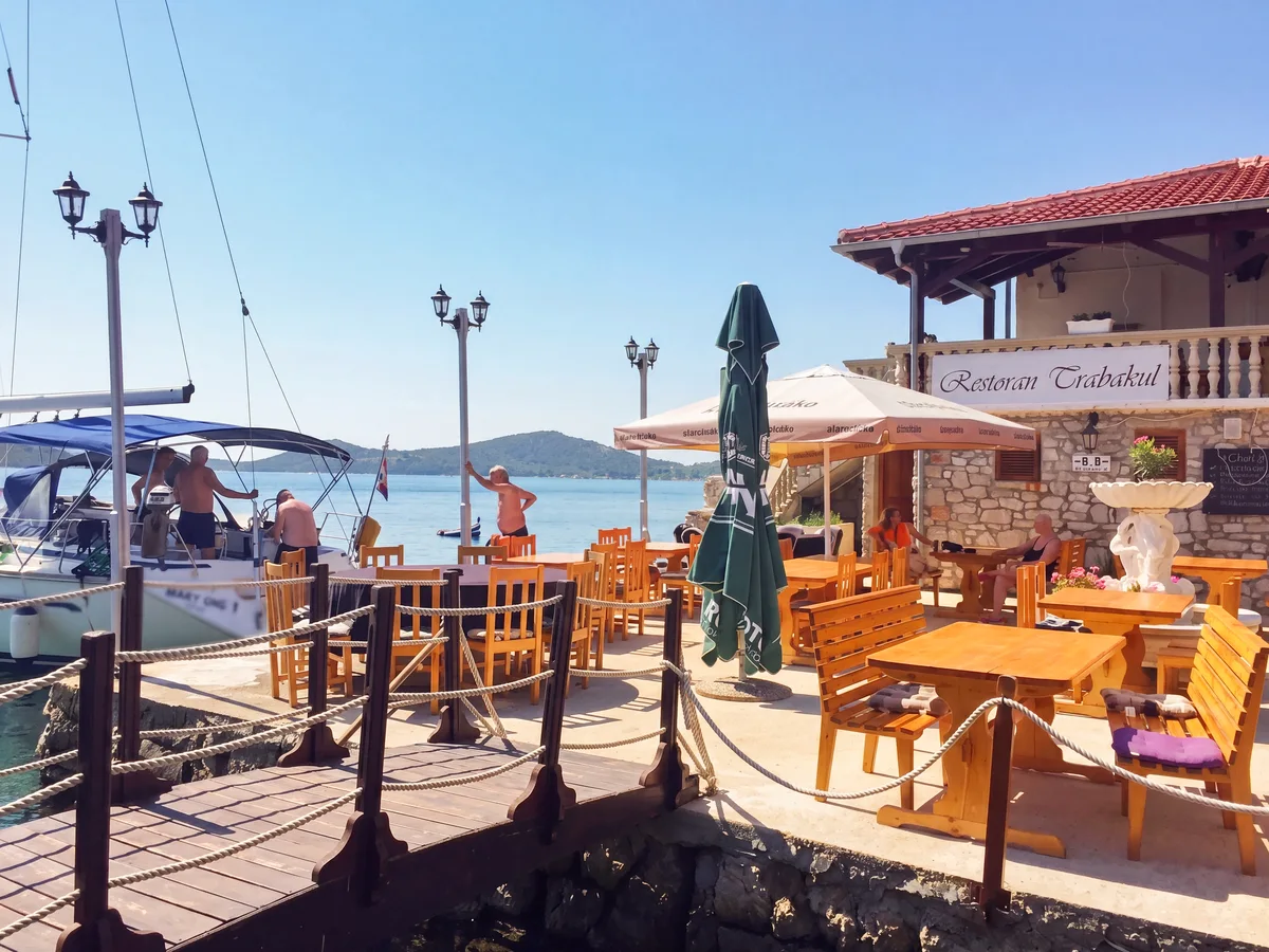 Trabakul Betina restaurant – daytime terrace overlooking the marina and boats in Betina harbour, Murter